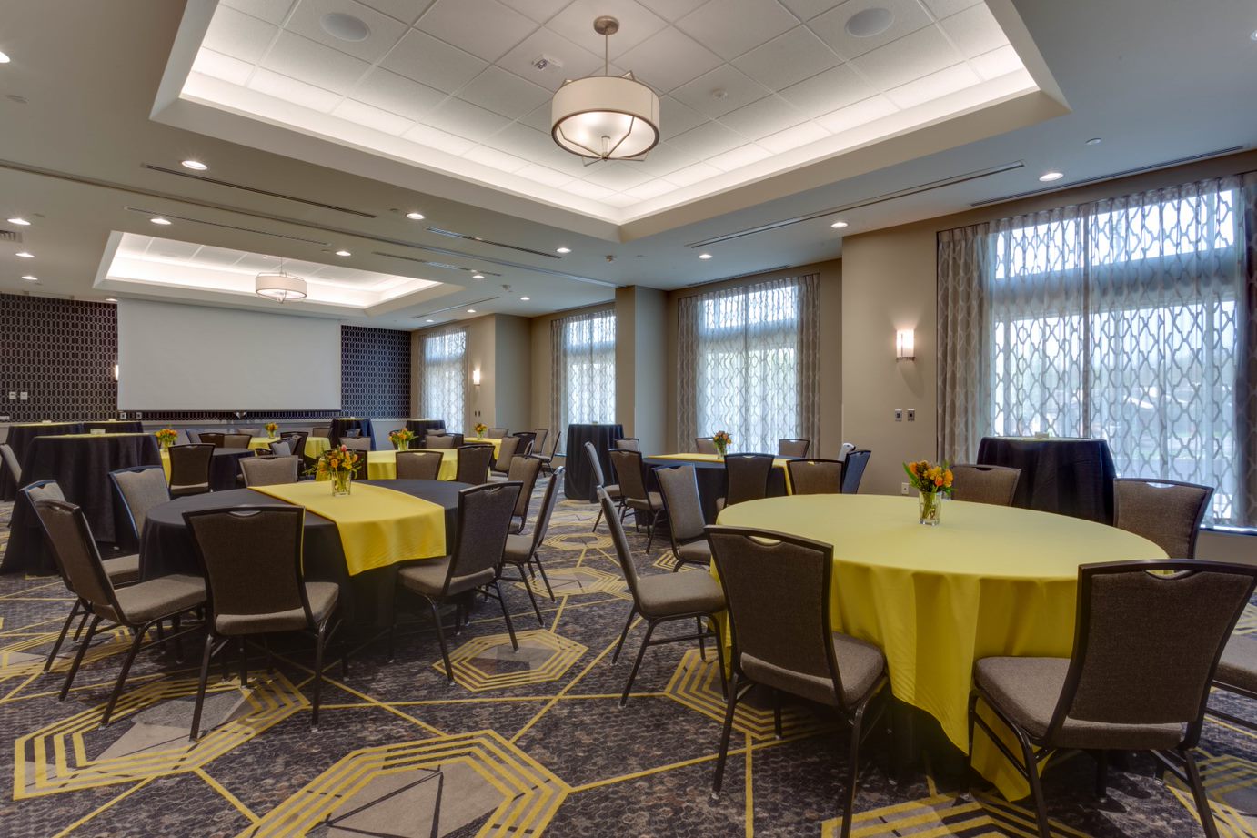 Meeting space with round tables and large projector screen